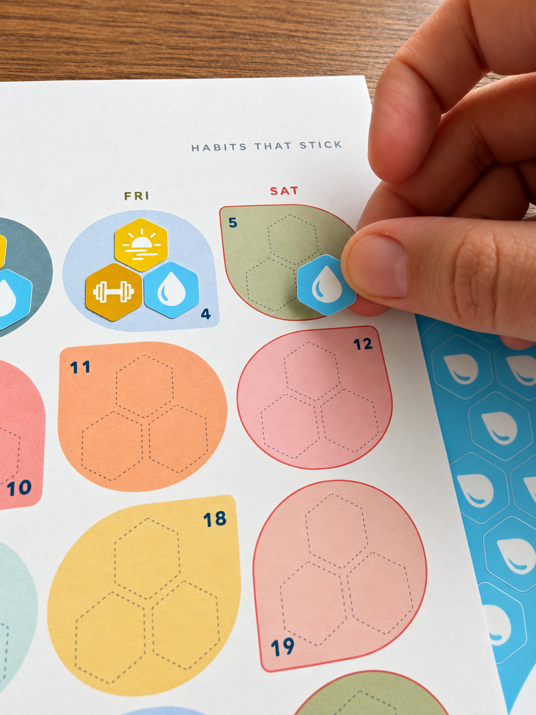 Placing a habit sticker on the Stickto paper calendar