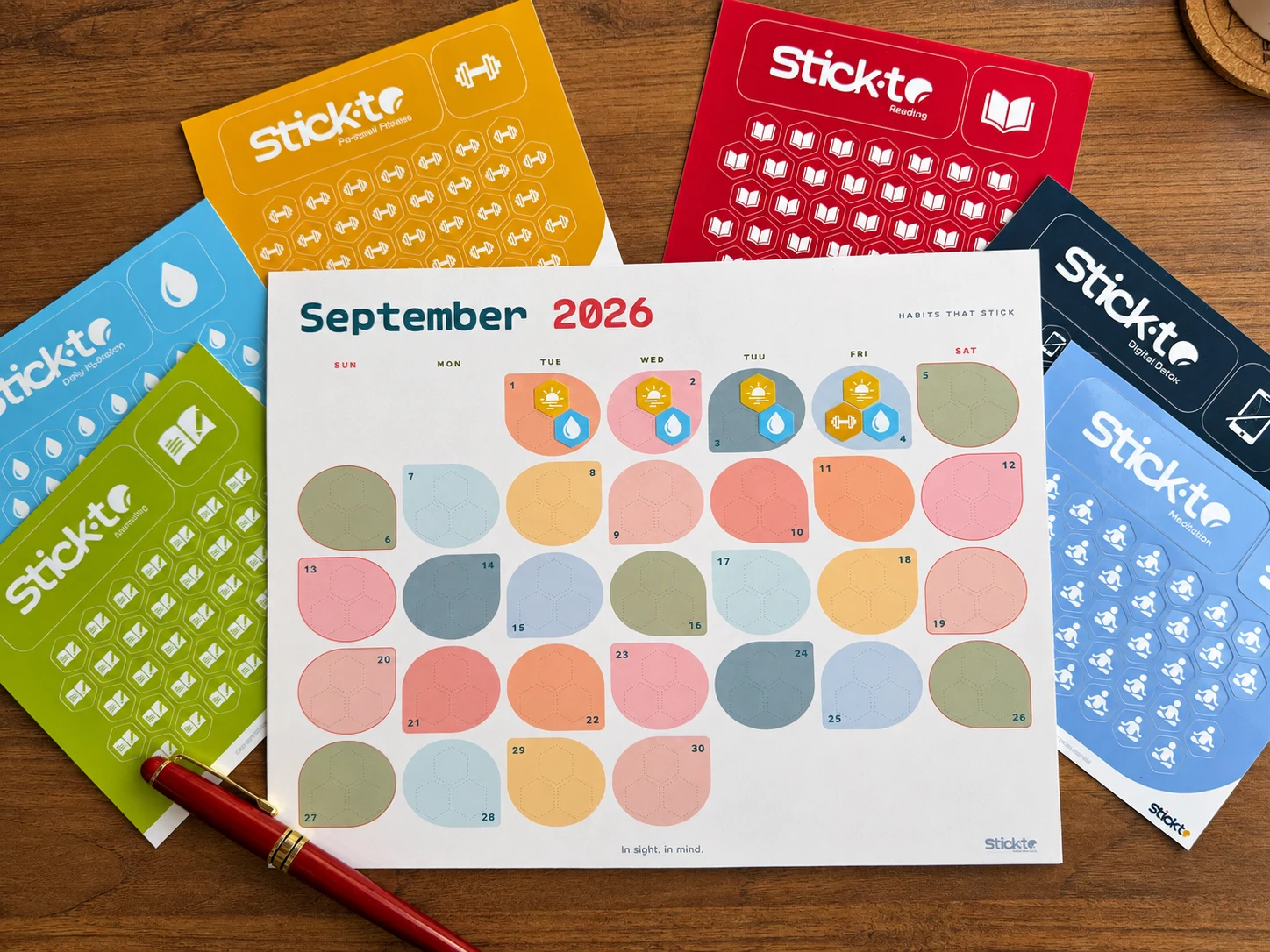 Colorful habit sticker sheets around a printable calendar